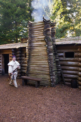 Sentry walking in front of a Fort Clatsop chimney